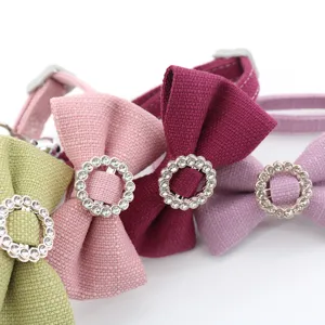 Closeup detail of pet collar featuring fabric bow and sparkly rhinestone ring in vibrant colors.