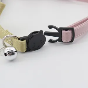 Cute cat collar with safety buckle and bell, pink and yellow fabric pet accessory detail.