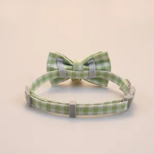 Green and white plaid pet collar with cute bow and bell for cats and small dogs safely.