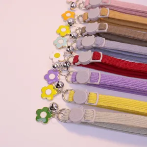 Corduroy pet collar detail showing colorful straps, cute flower charm, and safe cat buckle.