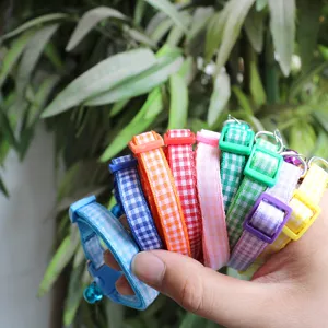 Colorful plaid fabric pet collar with bell detail, adjustable and comfortable for pets.