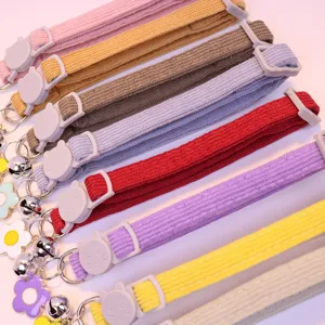 Close-up detail of soft corduroy pet collar with cute cat buckle, bell, and flower pendant.