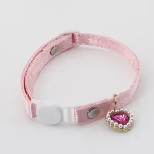 Pink satin pet collar detail view showing the cute heart diamond pendant and white cat buckle.