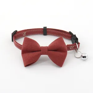Red denim pet collar detail, vintage bowknot and metal bell, close up shot for cats and small dogs.