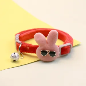 Cute plush rabbit pet collar detail, featuring soft red strap, bunny head and bell.