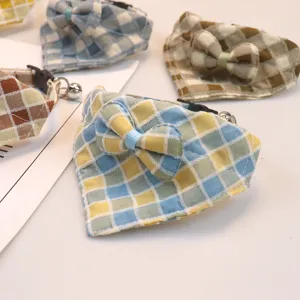 Cute plaid pet bib collar with bow and bell for cats and dogs, detailed view of soft fabric.