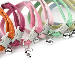 Colorful pet collar detail featuring soft fabric webbing, durable buckle, and a clear ringing bell.
