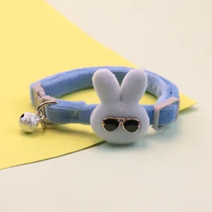 Detailed view of cute blue plush pet collar featuring a rabbit with sunglasses and a bell.