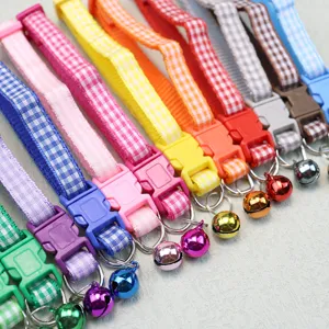 Colorful plaid pet collar detail featuring plastic buckle, D-ring and small cute bell.