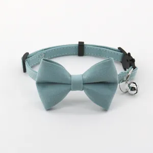 Close up detail of cute blue bowknot pet cat collar featuring a shiny metal bell and buckle.
