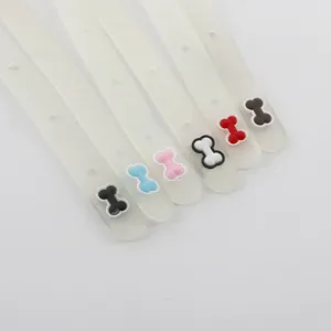 Close-up of translucent pet collar straps with colorful bone charms, detail shot.