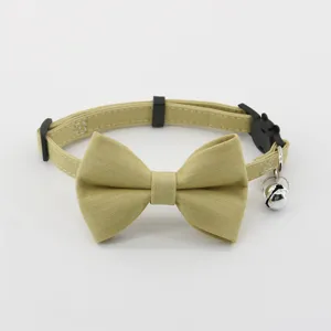 Pet collar detail shot showcasing the elegant khaki fabric bowknot and ringing bell accessory.