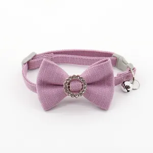 Close up detail of purple pet collar featuring sparkly rhinestone bow and metal bell.