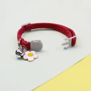 Detailed view of the red corduroy pet collar featuring a cute bell and lovely flower charm.