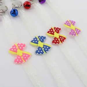 Colorful polka dot bow pet collar detail featuring cute metal bells and transparent strap design.