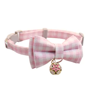 Pink plaid pet collar with bow and bell, detailed view of cute cat and dog neck accessories.