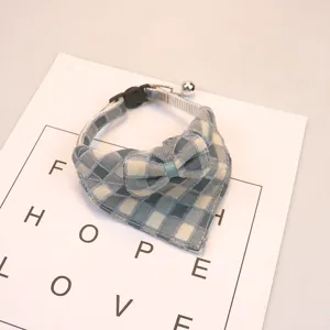 Close-up detail of the cute blue plaid pet collar with bow and bell for cats and dogs.