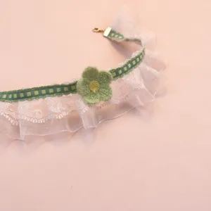Close-up detail of the cute pet lace choker with a handmade crochet green flower and ribbon.