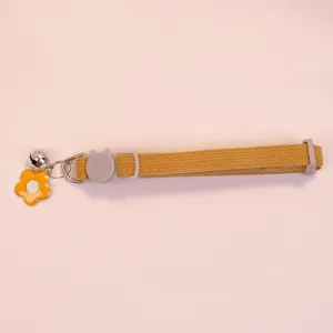 Detailed view of yellow corduroy pet collar featuring cute flower pendant and bell decoration.