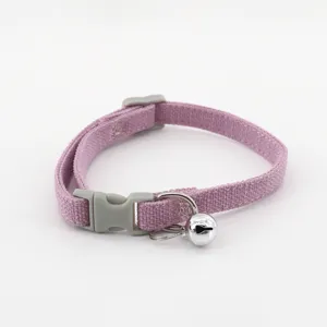Close-up detail of the pink pet collar fabric, featuring a durable gray buckle and hanging bell.