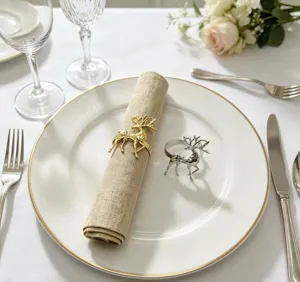 Detailed view of gold and silver metal reindeer napkin rings on elegant table setting.