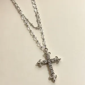 Detailed view of Y2K style layered cross beaded necklace with sparkling zircon stones.