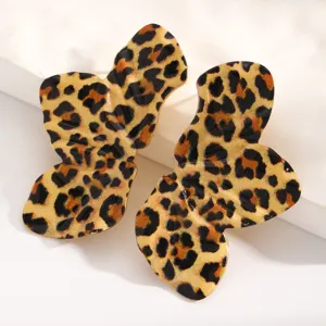 Close-up of alloy earrings with leopard print, abstract leaf design, and smooth metallic finish.