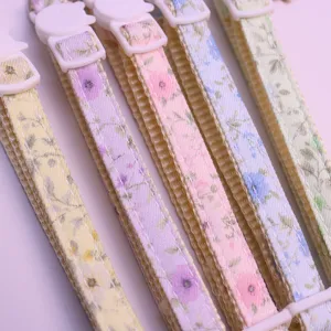 Close-up of floral pet collar details, featuring fresh floral prints and plastic buckles.