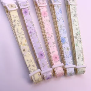 Close-up detail of colorful floral pet collars with white plastic adjusters, soft and fresh.