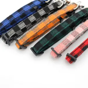 Close-up detail of colorful plaid pet collars featuring bells and adjustable buckles for cats dogs.