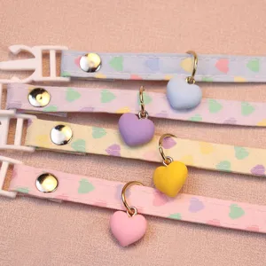 Cute heart charm pet collar detail showing adjustable safety buckle and colorful fabric design.