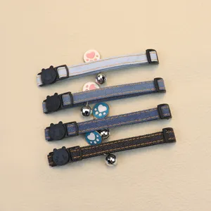Adjustable denim pet collar with bell and cute paw pendant for cats and dogs daily wear.