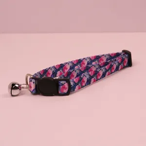 Floral cat collar detail showing vintage print, safety buckle, and small bell accessory.