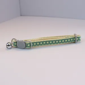 Green plaid pet collar detail featuring cute cat buckle, metal bell and D-ring for small cats.