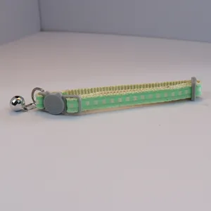 Green plaid pet collar detail, featuring cute cat face buckle and silver bell for cats.