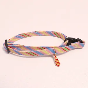 Detailed close-up of colorful striped pet collar with cute tie pendant for cats and dogs.