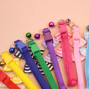 Gros plan détaillé de colliers pour animaux colorés avec de jolis nœuds et des cloches.