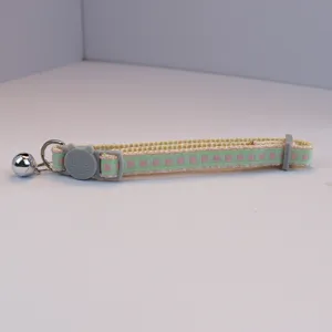 Close-up detail of cute plaid pet cat collar with cute cat buckle and hanging bell.