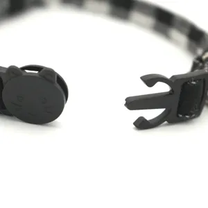 Black and white plaid pet cat collar featuring a cute cat-shaped safety release buckle macro shot