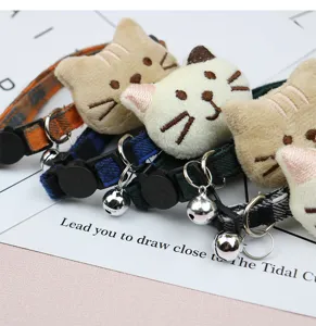 Plush cartoon cat head pet collar with cute bell, adjustable fabric strap for cats and small dogs.