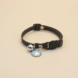 Close-up detail of the denim pet collar, featuring a cute blue paw pendant and silver bell.