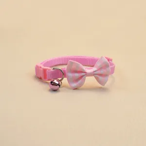 Gros plan détaillé du joli collier pour animal rose avec nœud rayé et cloche métallique.