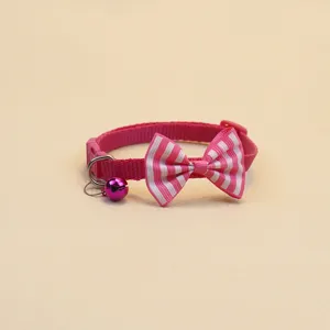 Vue détaillée du collier pour chat et chien rayé rose et blanc avec nœud et cloche.