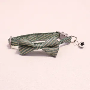 Green and gold striped pet collar with bow, safety buckle and bell for cats and dogs details.