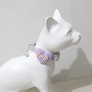 Dettaglio collare per animali in peluche con grazioso ciondolo a cuore, fiocco e campanello per gatti.