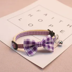 Cute purple plaid pet collar with bow and bell for cats and small dogs detail close up view.