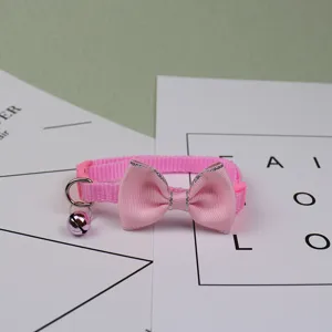 Pink pet cat collar detail showcase with sweet bowknot and metallic bell for charming look.