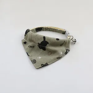 Green cat bandana with cute print and bell, ideal for close-up pet accessory detail view.