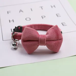 Pink velvet pet collar detail view featuring a cute bow and shiny metal bell.
