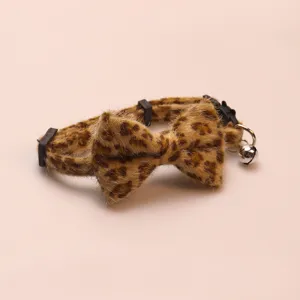 Leopard print plush pet collar detail shot with cute bowknot and metal bell, soft texture.